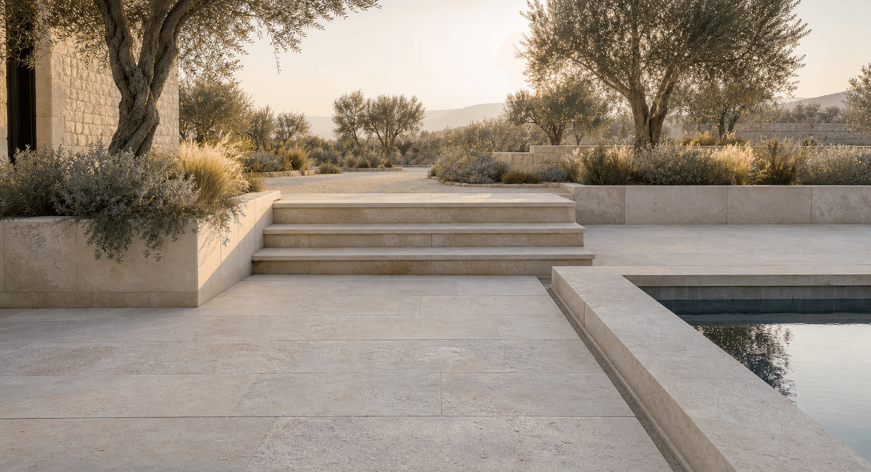 Warm natural stone paving, steps, planters, and pool coping